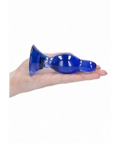 The blue glass butt plug on the palm of someones hand