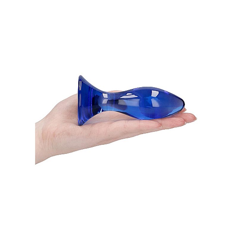 The blue glass butt plug on the flat of a persons hand