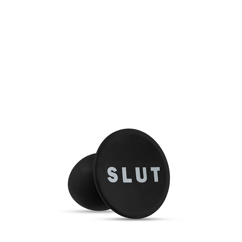 The base of the black anal plug with the word SLUT in white letters