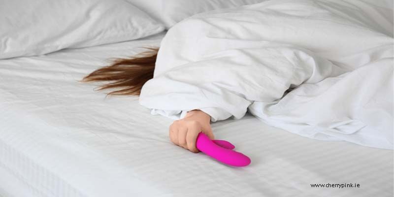 The Best Vibrators For Beginners Blog Image of a girl in bed holding a rabbit vibrator.