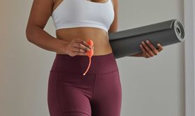 A Beginners Guide to Kegel Exercises image of a girl folding Kegel Balls and an exercise mat.